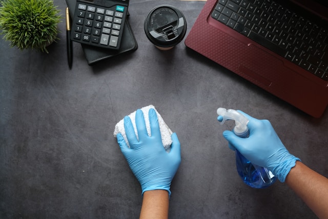 a person spraying a bottle of cleaning spray