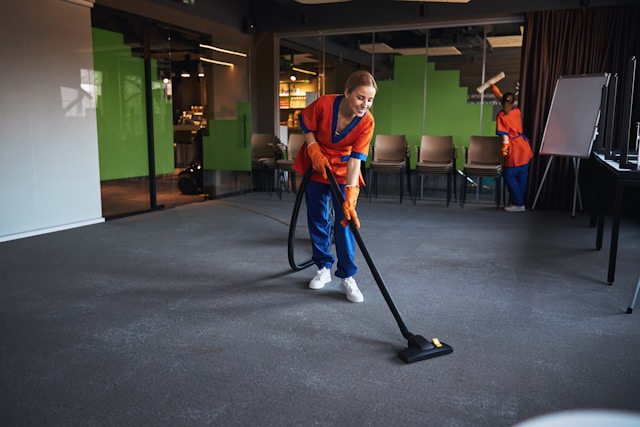 A cleaner vacuuming an office floor