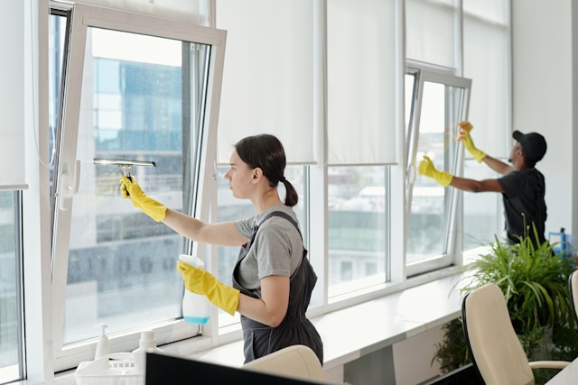 workers cleaning a window in an office